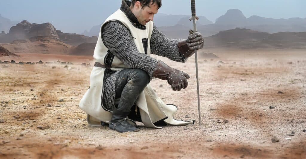 Armored paladin praying in desert