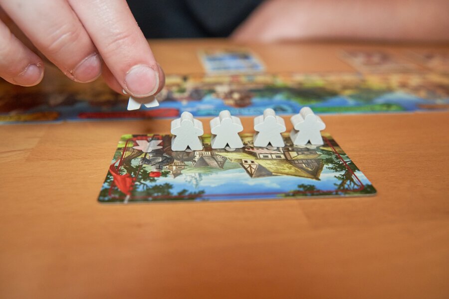 five white meeples on board game tile